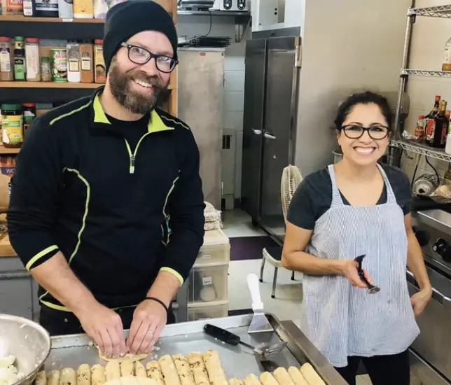 John and Rebeca Stenson preparing food together in a kitchen