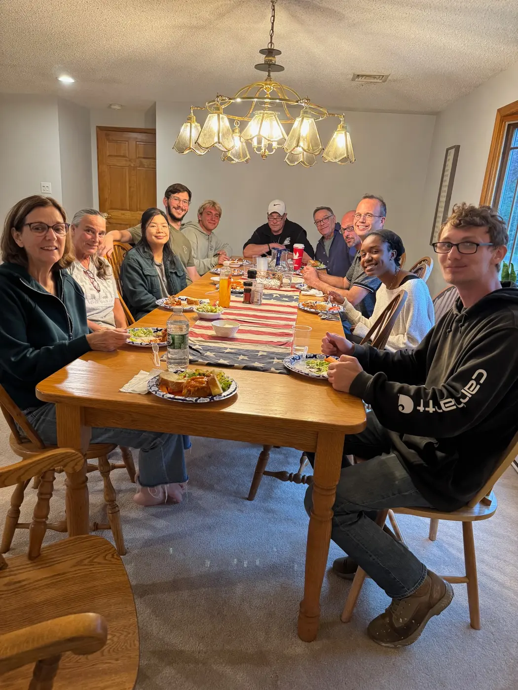 A multigenerational group sharing a meal around a table at Haven House