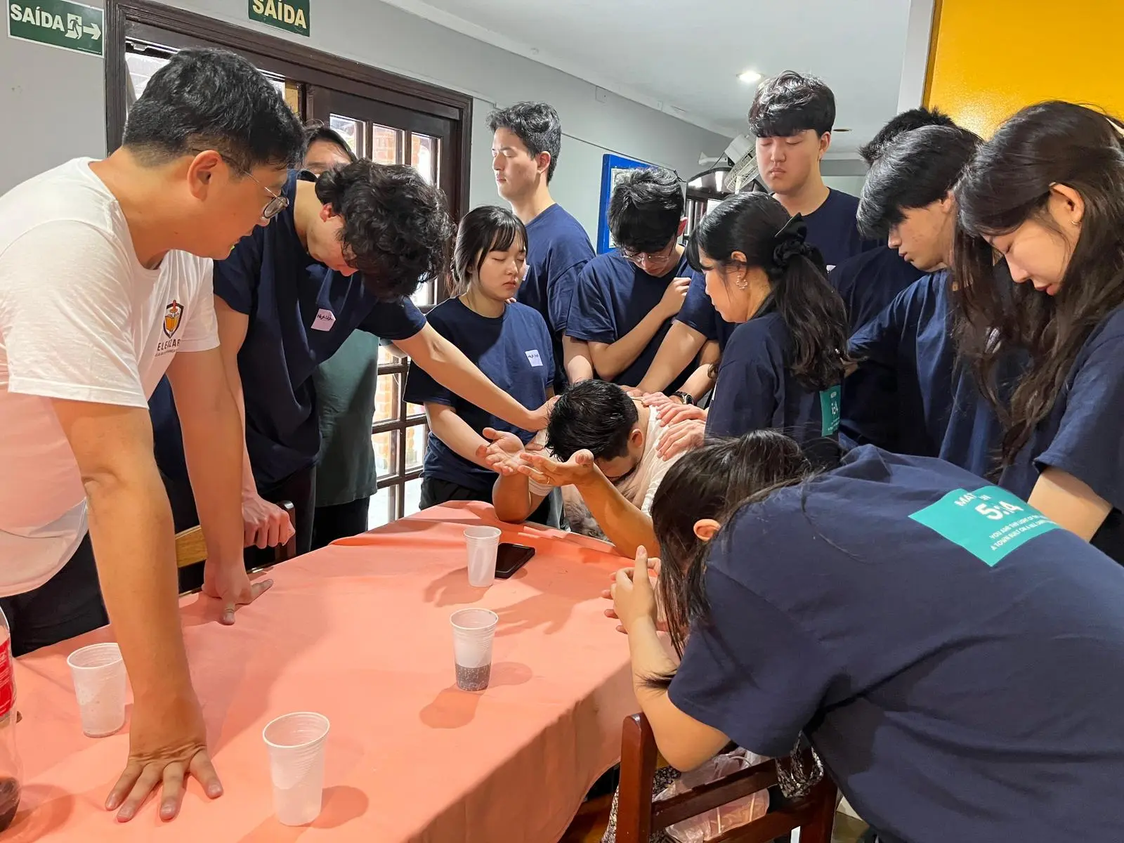 University students gathered closely in prayer