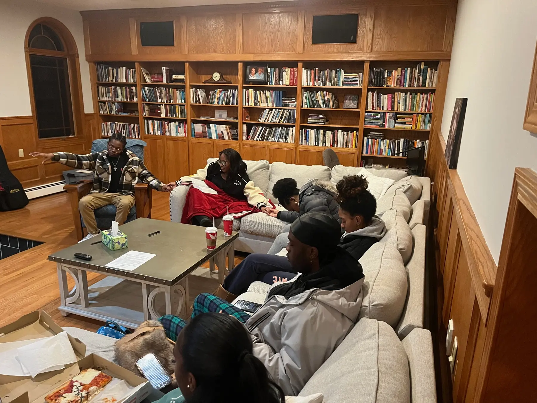 Young adults gathered for Bible study in a home library