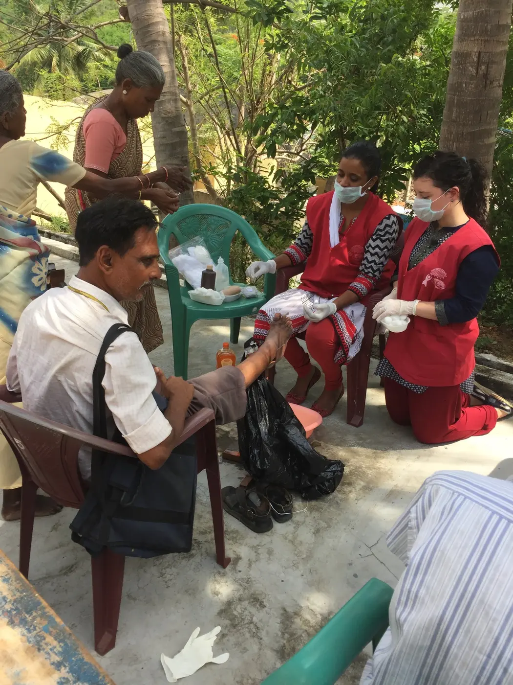 A medical outreach team providing foot care outdoors in India