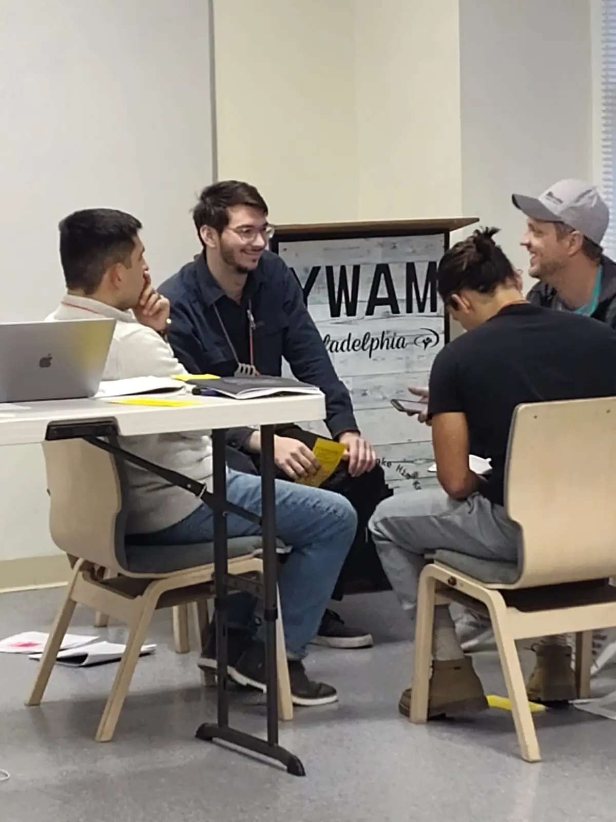 Four men talking together around a table